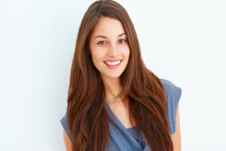 Een jong meisje dat lacht en haar rechte tanden laat zien