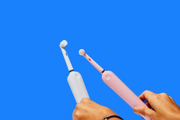 Witte en roze elektrische tandenborstels op een blauwe achtergrond