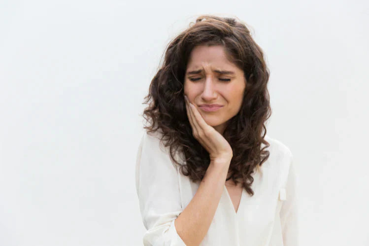 Een vrouw houdt haar kaak vast vanwege kiespijn.